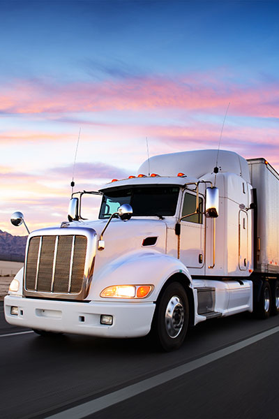 Truck and highway at sunset - transportation background